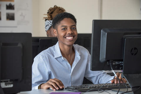 individual smiling at the computer