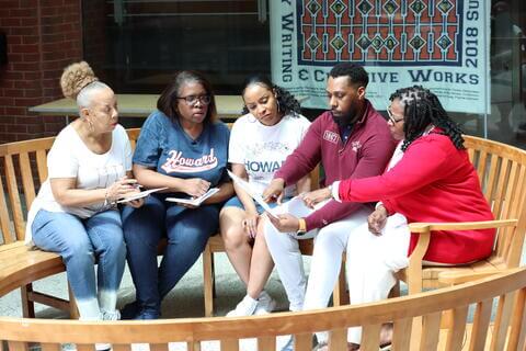 employees sitting together and looking at a document 