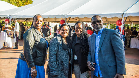 Howard University staff smiling on a sunny day at a celebration on the Yard.
